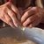 Elderly hands cracking an egg into a bowl of flour