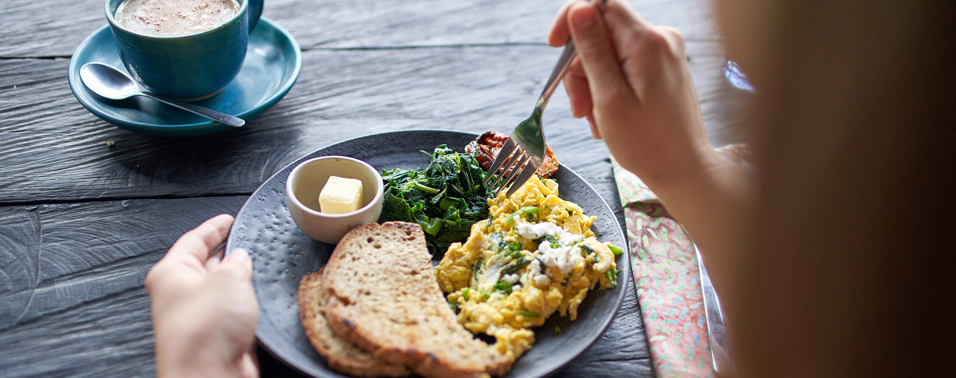 Over the shoulder view of woman eating breakfast