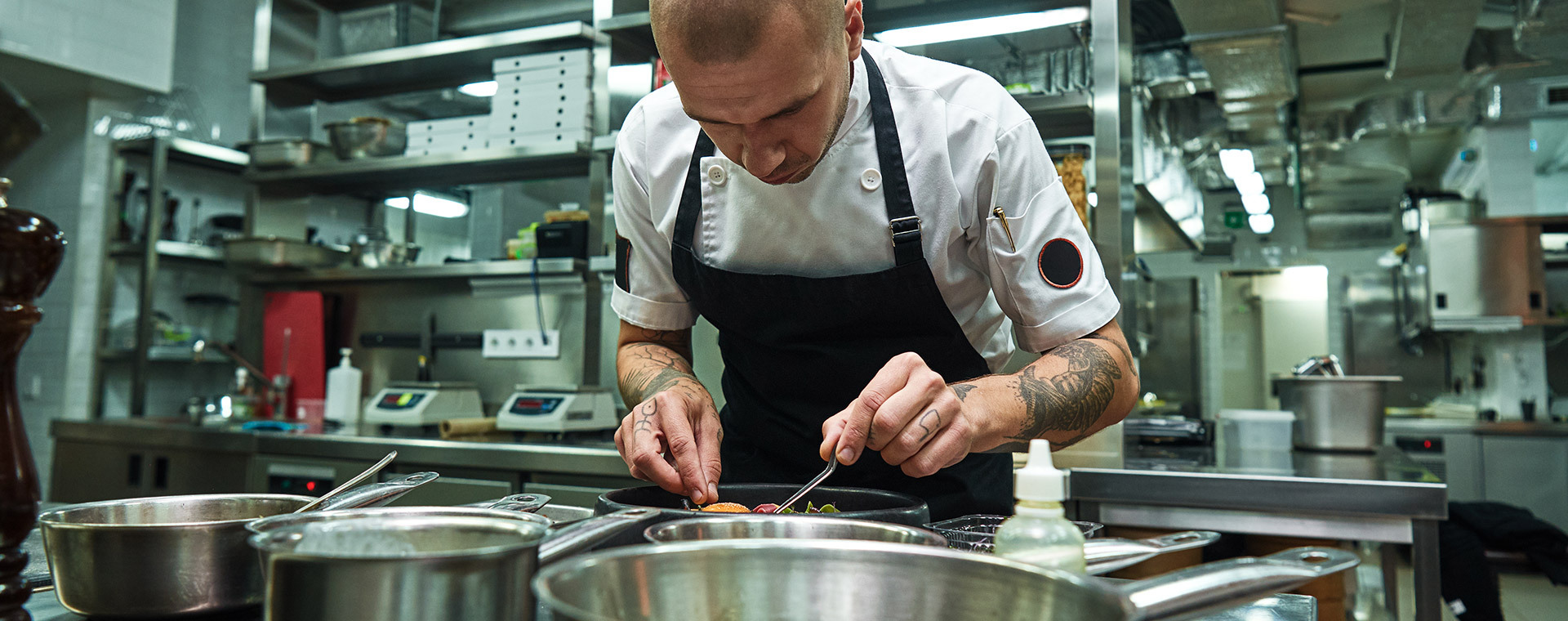 Sous chef plating food in commercial kitchen