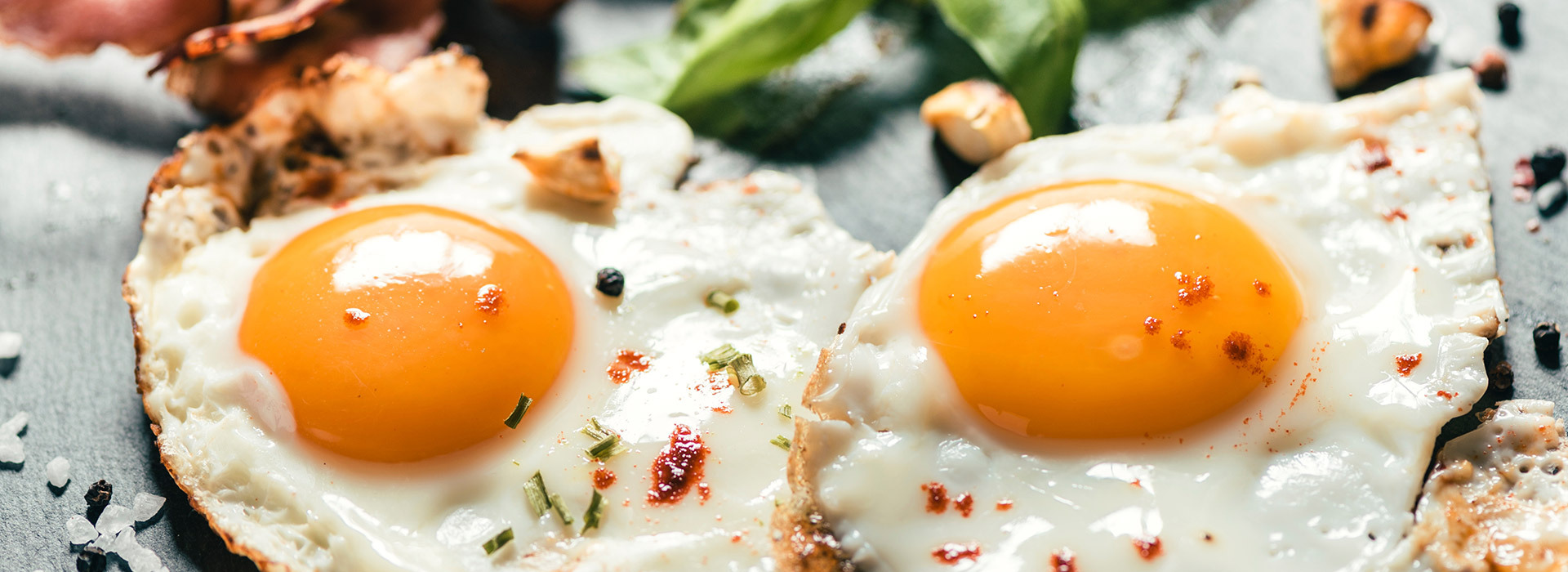 Two fried eggs garnished with dill weed and red pepper flakes