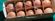 A dozen brown eggs in a unique egg carton with string handles