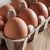 Brown eggs in an egg carton on table