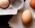 One white egg and two brown eggs sitting on white napkin