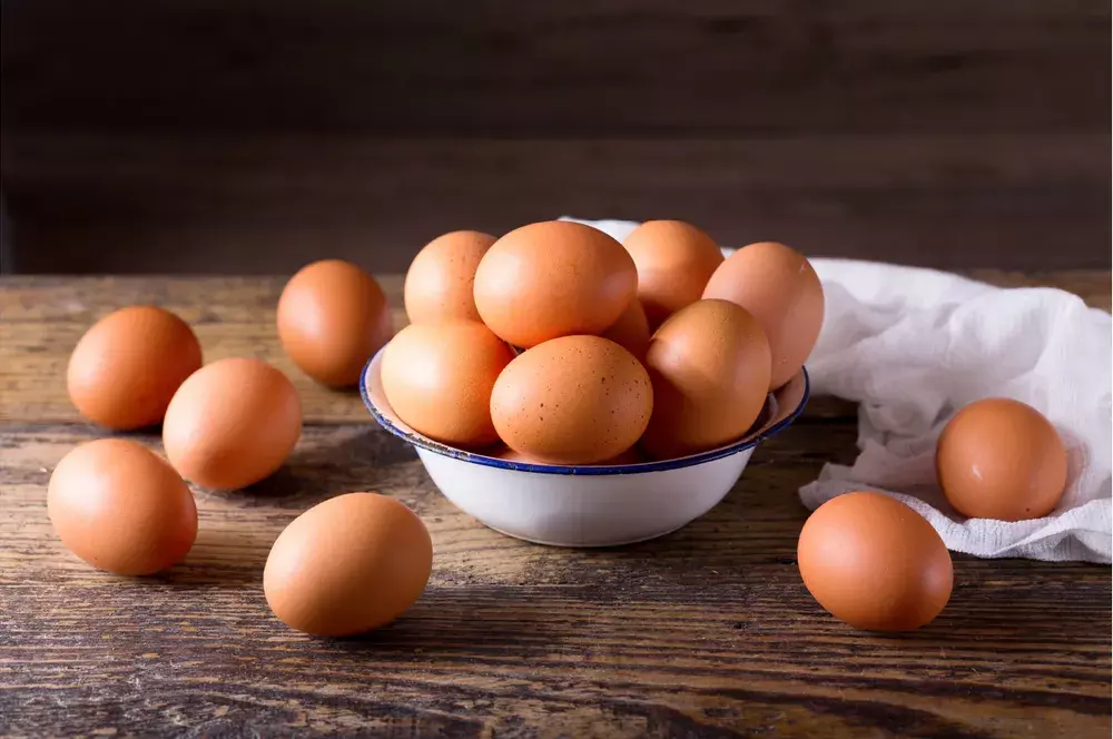 Brown eggs overflowing in a small white bowl