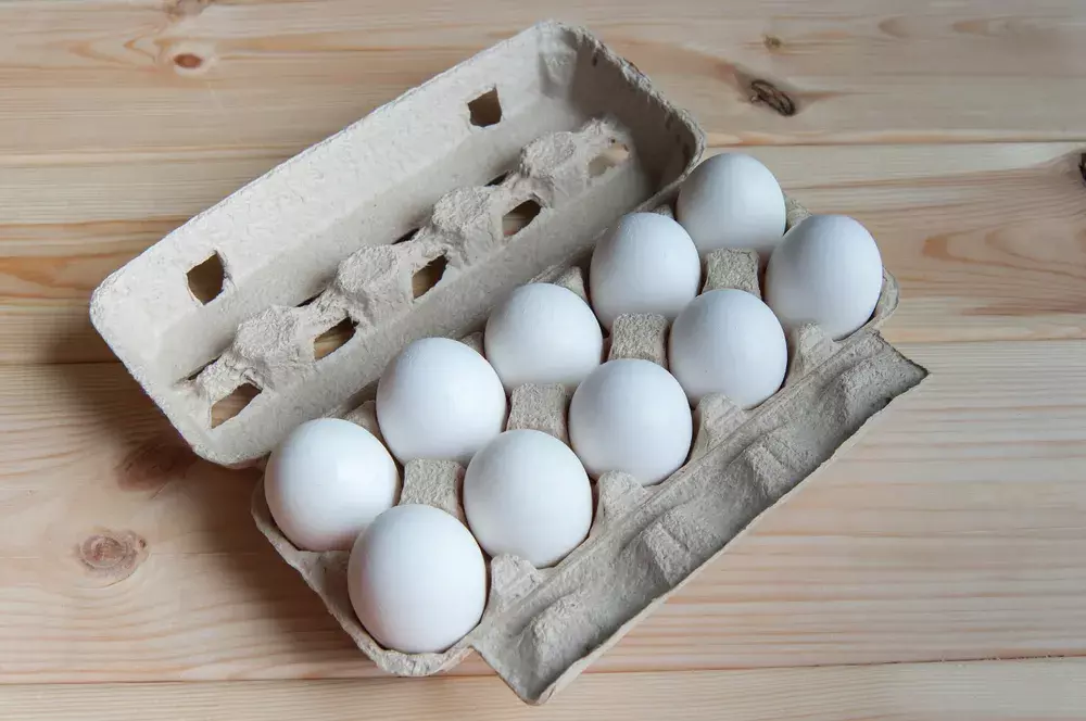 An open egg carton filled with white eggs