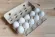 An open egg carton filled with white eggs