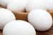 Close up of white eggs in a bowl with eggs on table