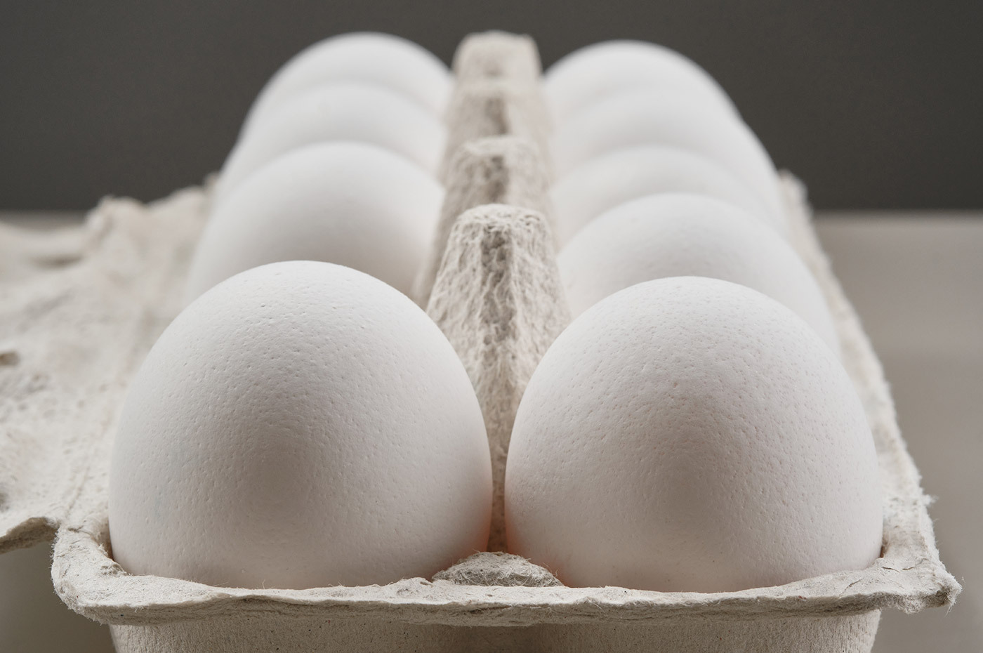 Two rows of classic white eggs in an egg carton