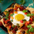 A plate of nachos libres with an egg on top.